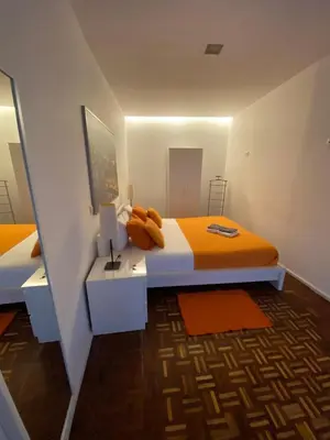 a bedroom with two beds with orange pillows on it at AP da Baixa in Porto