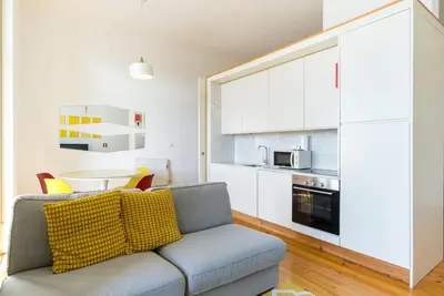 a living room with a couch and a kitchen at GuestReady - Urban oasis with private balcony in Porto