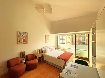 a hotel room with a bed and two chairs at PORTO SWEETHEART - Almada in Porto