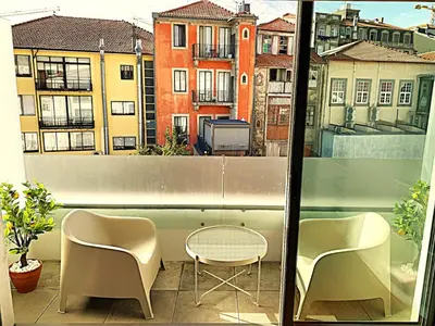 a balcony with two chairs and a table and a window at PORTO SWEETHEART - Almada in Porto