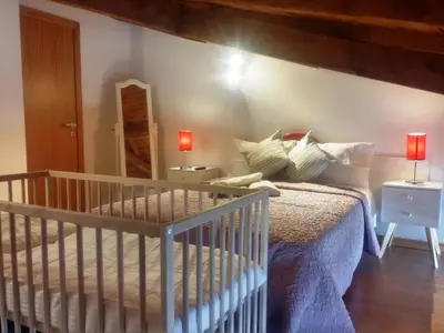 a bedroom with a crib and a mirror at Casa São Dinis in Porto
