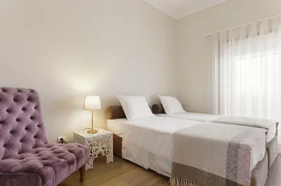 a bedroom with a bed and a couch and a chair at Chateau Belomonte in Porto