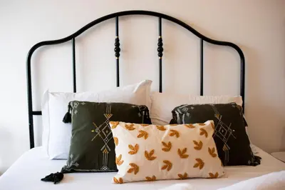 a bedroom with a black and white bed with pillows at Oporto Trindade Residence in Porto
