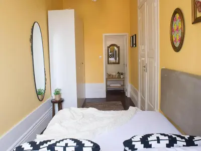a bedroom with yellow walls and a bed and a mirror at Merc Porto Central Place in Porto