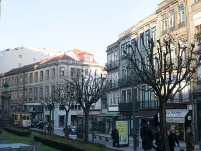 a group of buildings on a city street with trees at Merc Porto Central Place in Porto