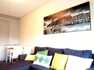 a living room with a blue couch with yellow pillows at Santa Catarina Cozy Nest - Porto Downtown in Porto