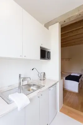 a kitchen with a sink and a bed in a room at Casa da Figueiroa in Porto