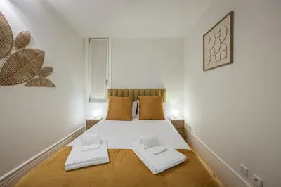 three framed pictures on a white wall with lights at Aliados Town Hall in Porto