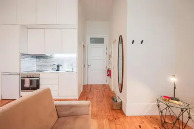 a kitchen with white cabinets and a dining room at Aliados Town Hall in Porto