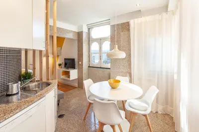 a small kitchen with a white table and chairs at D&S - Ribeira Premium Apartments in Porto