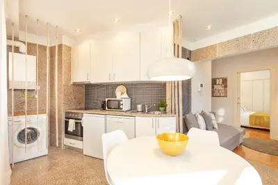 a kitchen and living room with a white table and chairs at D&S - Ribeira Premium Apartments in Porto