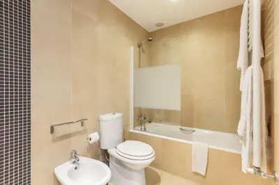a bathroom with a toilet and a tub and a sink at D&S - Ribeira Premium Apartments in Porto