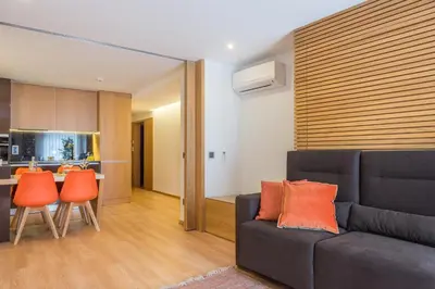 a living room with a couch and orange chairs at Almada Domus in Porto