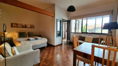 a bedroom with a bed and a living room with a couch at Studio DOWNTOWN in Porto