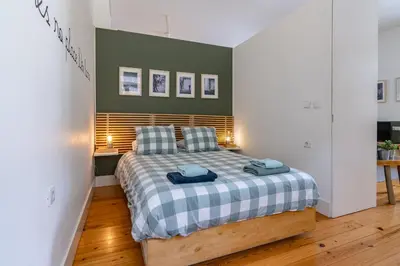 a bedroom with a bed with blue towels on it at Cozy Studio Apartment in Porto