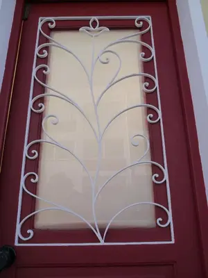 a red door with a wrought iron window at Apartamento Boavista in Vila Nova de Gaia