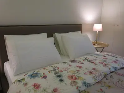 a bed with a table with a lamp on it at Chateau Flores in Porto