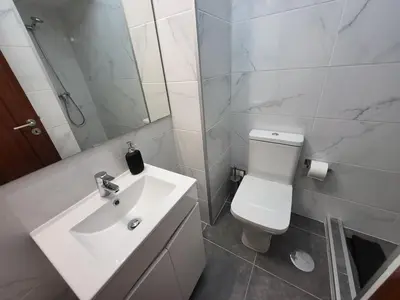 a bathroom with a white toilet and a sink at Vale Formoso Apartment in Porto