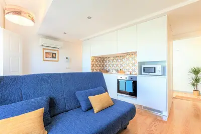 a living room with a blue couch and a kitchen at Sendme2Portugal: Loureiro in Porto