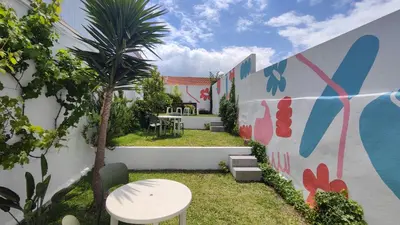 a garden with a wall with a table and chairs at O'Porto Cheers Gaia in Vila Nova de Gaia