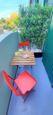 a red chair and a wooden table on a balcony at Boavista Class Inn in Porto