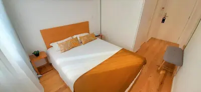 a small bedroom with a bed with white sheets and pillows at Boavista Class Inn in Porto