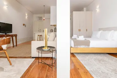 a bedroom and a living room with a bed and a table at Studio Sta in Porto