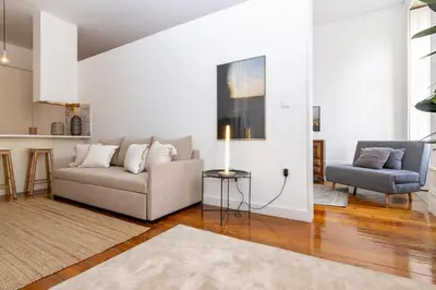 a living room with a couch and a chair at Studio Sta in Porto