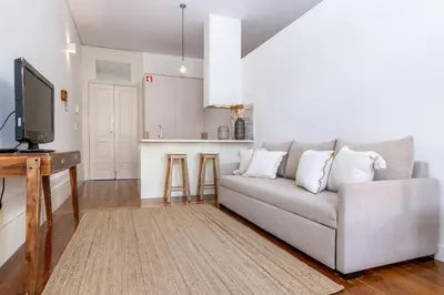 a living room with a couch and a kitchen at Studio Sta in Porto