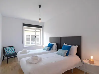 two beds in a room with a window at FLH Porto Comfort Flat in Porto