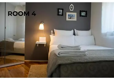 a bedroom with a bed with white sheets and a lamp at BCharming House in Porto