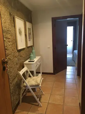 a hallway with a chair and a table and a door at Turra Residence in Porto