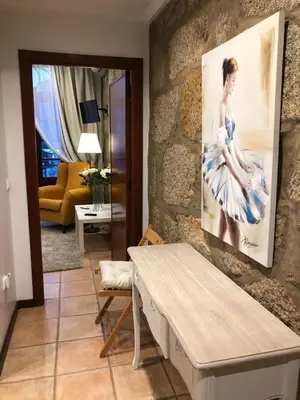 a living room with a painting of a woman on the wall at Turra Residence in Porto
