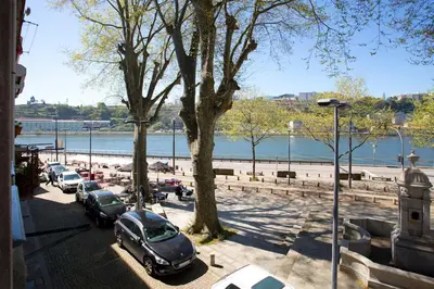 a parking lot with cars parked next to a beach at 14º Esquadra — Cais das Pedras Guest House in Porto