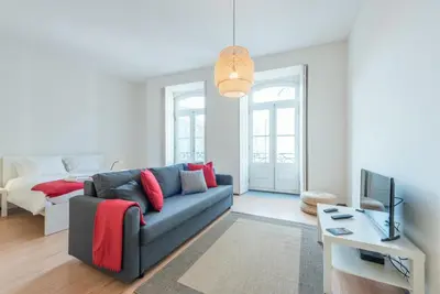 a living room with a blue couch and a television at GuestReady - Clérigos Virtudes Apartments in Porto