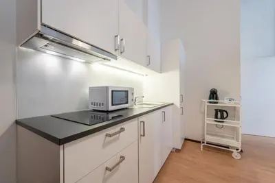 a kitchen with white cabinets and a computer on a counter at GuestReady - Clérigos Virtudes Apartments in Porto