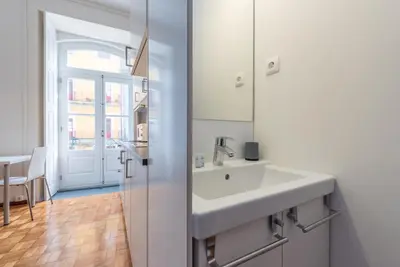 a white bathroom with a sink and a mirror at GuestReady - Clérigos Virtudes Apartments in Porto