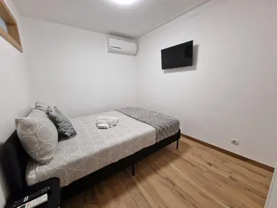 a small bedroom with a bed and a flat screen tv at Cozy Apartment with Terrace, Air Cond, Free Parking, by Porto with Love LDA in Porto