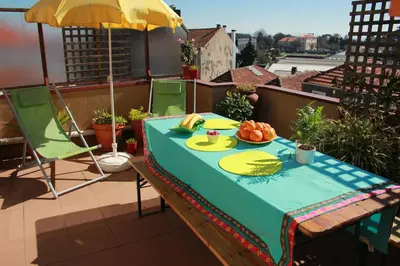 a table with a plate of food on a balcony at Cozy Apartment with Terrace, Air Cond, Free Parking, by Porto with Love LDA in Porto