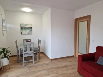 a living room with a table and a red couch at Cozy Apartment with Terrace, Air Cond, Free Parking, by Porto with Love LDA in Porto