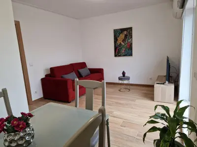 a living room with a table and a red couch at Cozy Apartment with Terrace, Air Cond, Free Parking, by Porto with Love LDA in Porto