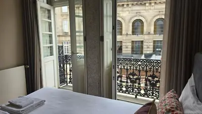 a room with a bed and a balcony with a window at São Bento Front Homy Studio in Porto