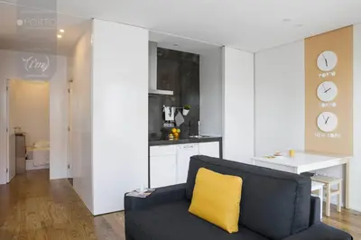 two pictures of a waiting room with a yellow chair at ORM - Saraiva de Carvalho Apartments in Porto