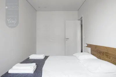a white room with a bed with white sheets and pillows at ORM - Saraiva de Carvalho Apartments in Porto