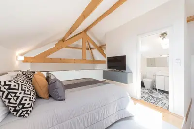 a white bedroom with a bed and a television at LovelyStay-Modern Loft City Center in Porto