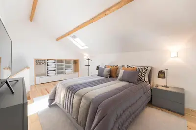 a bedroom with a large bed in a white room at LovelyStay-Modern Loft City Center in Porto