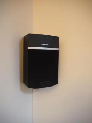 a black speaker hanging on a wall at Flores Lofts in Porto