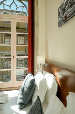 a living room with a white couch and a window at Flores Lofts in Porto