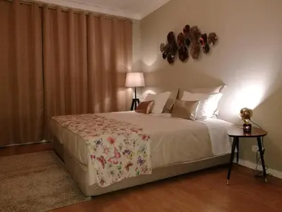 a bedroom with a bed and a lamp and curtains at Pontocom Bolhão Apartment in Porto