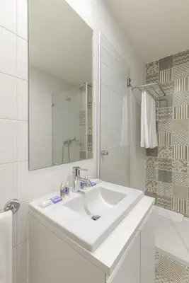 a white bathroom with a sink and a mirror at Charming Balcony Apartment in Historic Ribeira - Inside Porto Apartments 